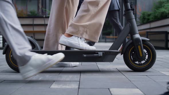 Close Up Female Legs Riding Kickscooter on Street Going Away