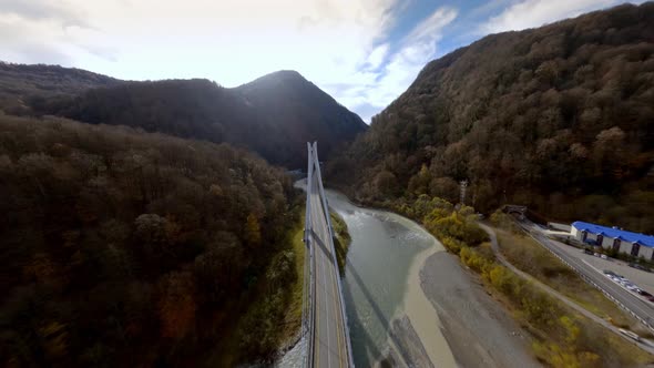 Aerial View Amazing Nature Scenery Mountain Terrain Red Sport Car Driving on Cable Stayed Bridge