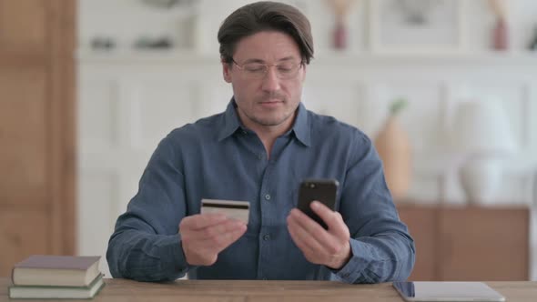 Young Man making Successful Online Payment on Smartphone