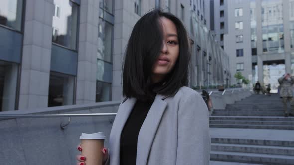 Young Adult Asian Businesswoman Turning Her Head and Looking at Camera