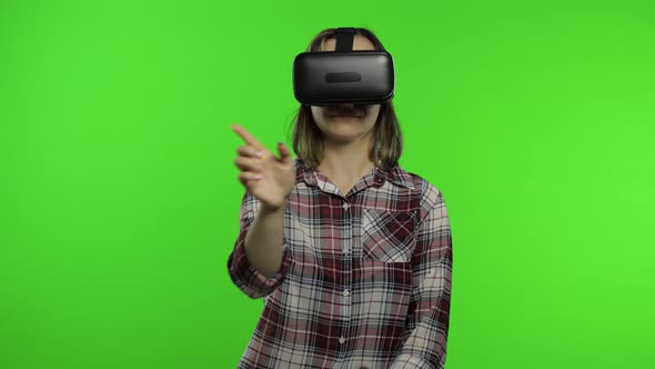 Girl Using VR App Helmet To Play Simulation Game. Slide Gestures. Watching Virtual Reality 3d Video