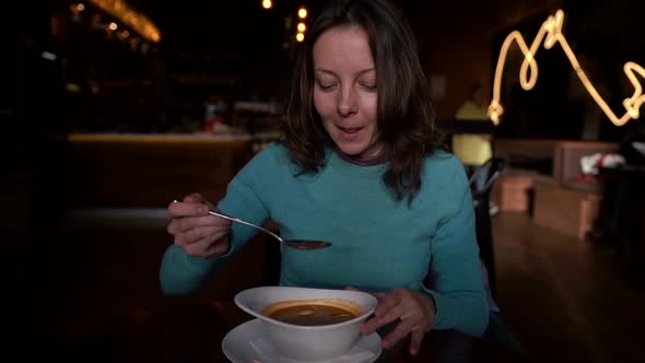 Adult Woman Is Dining Alone in Small Cafe, Eating Hot Soup