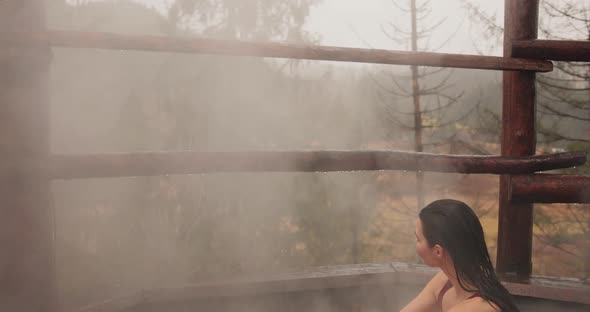 Woman in Bikini Bathing in Japanese Style Bath Outdoors