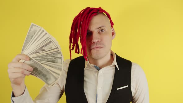 Happy Young Man with Red Dreadlocks Waving Dollar Bills