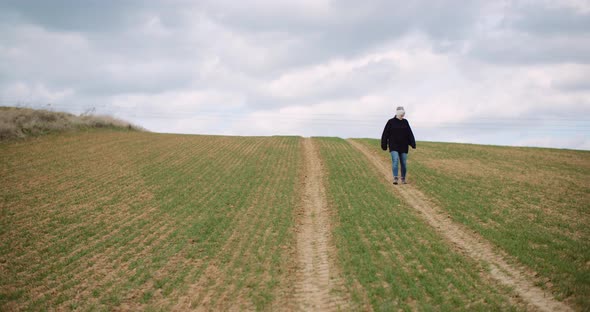 Agriculture - Female Farmer Walking on Agricultural Field