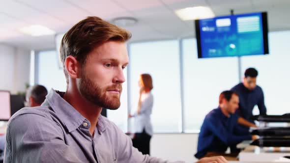 Male executive talking on telephone while working at desk