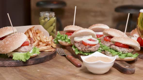 Smooth Parallax Shot of Wide Selection of Burgers on a Wooden Round Table