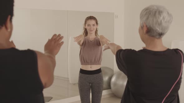 Fitness Trainer Showing Exercises to Mature Women