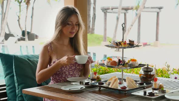 Woman Drinking Hot Coffee and Enjoy Sweet Bakery on Tropical Hotel Vacation