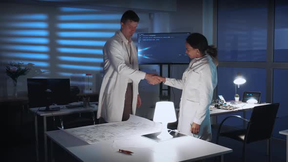 Two Diverse Scientists Giving Hands in Greeting on the Meeting in Lab