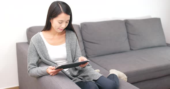 Woman using tablet computer at home