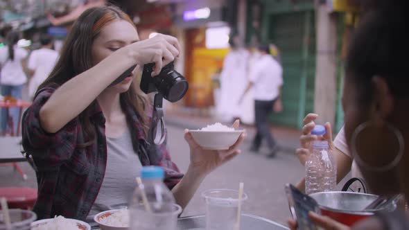 A group of multi-ethnic female friends enjoying street food on Yaowarat Road or Chinatown in Bangkok