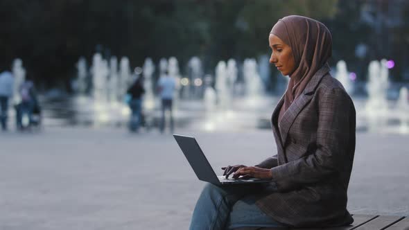 Young Successful Muslim Business Woman Islamic Student Girl Wears Hijab Sitting on Street City