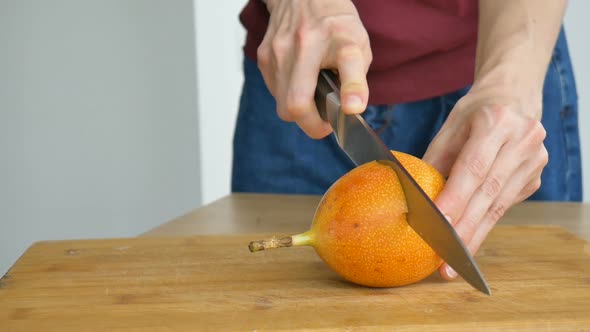 Fresh Organic Ripe Granadilla or Yellow Passion Fruit Cut in Half on a Wooden Board