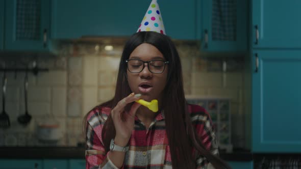 Young Adult African American Woman Wearing Birthday Hat Singing Happy Birthday Song at Camera at