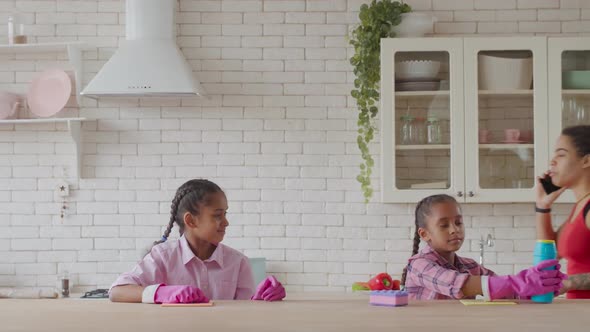 Little Sisters Helping Mom with Cleaning in Kitchen