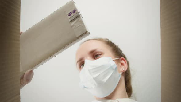 Young Woman Doctor Wearing Medical Mask and Gloves Taking Medicine From Box