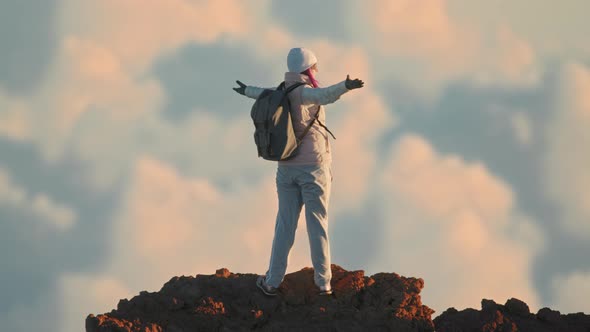 Cinematic Slow Motion Woman Victoriously on Top of Mountain Sunset Clouds View