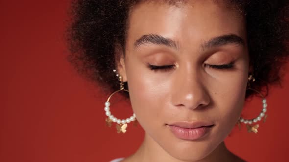 A close-up view of charming woman opening eyes and looking while camera moving