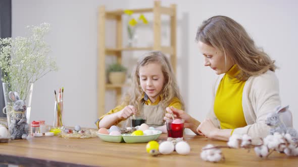 Mother and Daughter Dyeing Eggs before Easter