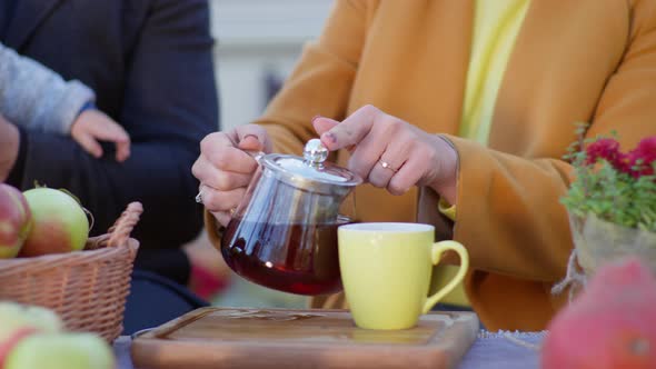 Tea for Family Outdoors Woman's Hand Pour Drink Into Cup and Give It To Little Son Kid Boy Does Not