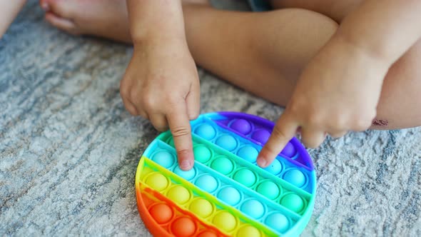 Cute Little Girls Playing with Enthusiasm Pop It Sensory Toy Circle Form