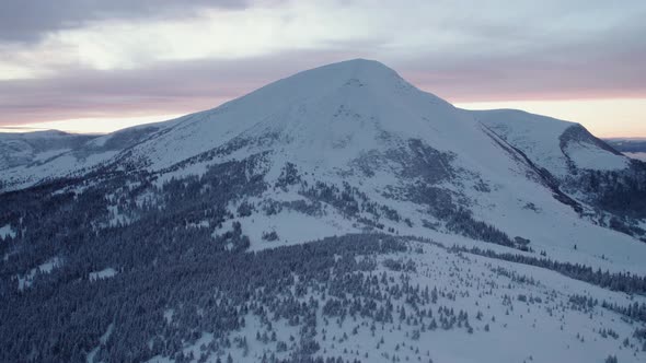 Rising above huge mountain range at sunset