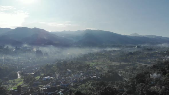 Cinematic aerial view of foggy valley with mountains in the morning