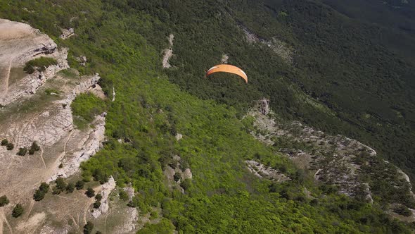 Paraglider Flies Over the Surface of the Earth in the Mountains of Crimea