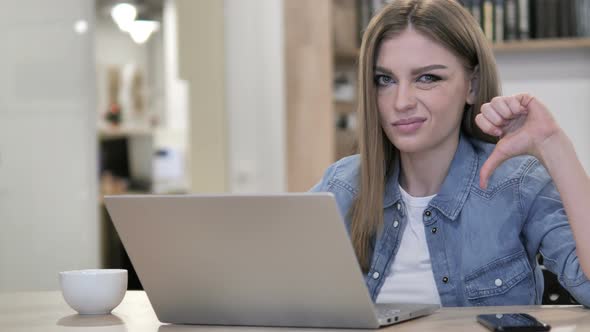 Thumbs Down By Creative Girl Looking at Camera at Work