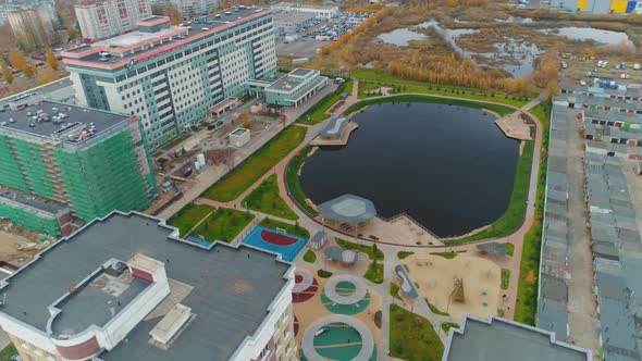 Pond with Beach Places and Green Lawn Near Dwelling District