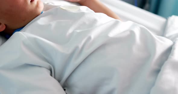 Patient resting with teddy bear on bed