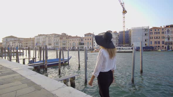 Girl Walking in Venice Near Gondolas, Italy