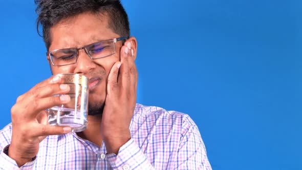 Young Man with Sensitive Teeth and Glass of Cold Water .