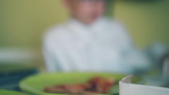 Student Takes Hotdog at Lunch with Schoolmate in Canteen