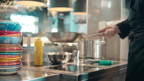 Food in a Frying Pan is Getting Tossed By a Cook