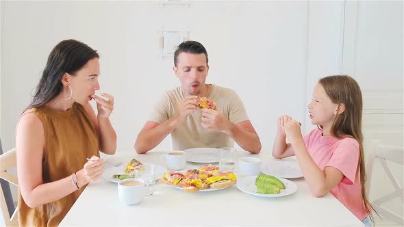 Happy Family Having Breakfast Together in Kitchen