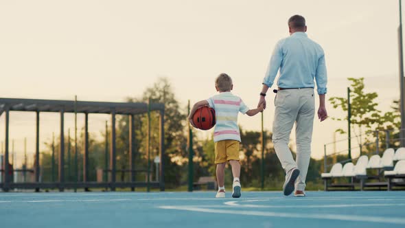 Father and son on the basketball court in summer