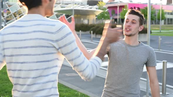 two young men outdoor handshaking smiling