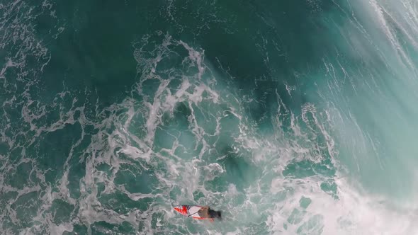 Aerial view of a man sup stand-up paddleboard surfing in Hawaii