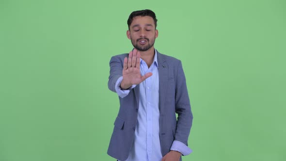 Serious Young Bearded Persian Businessman with Stop Gesture