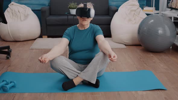 Aged Woman Using Vr Glasses to Meditate on Yoga Mat