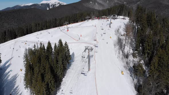 Aerial Ski Slopes with Skiers and Ski Lifts on Ski Resort. Snowy Mountain Forest