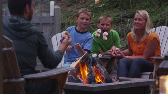 Family roasting marshmallows by outdoor fire. Shot on RED EPIC for high quality 4K, UHD, Ultra HD re