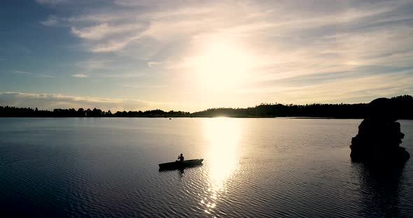 Beautiful Colorado sunrise on a lake with a silhouette of a canoe against the rising sun.  Shot take