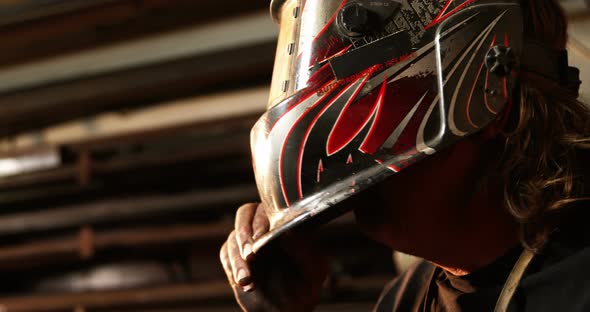 Welder wearing protective helmet