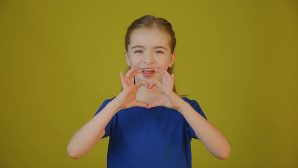 Kid Looking at Camera and Showing Heart Sign with Hands