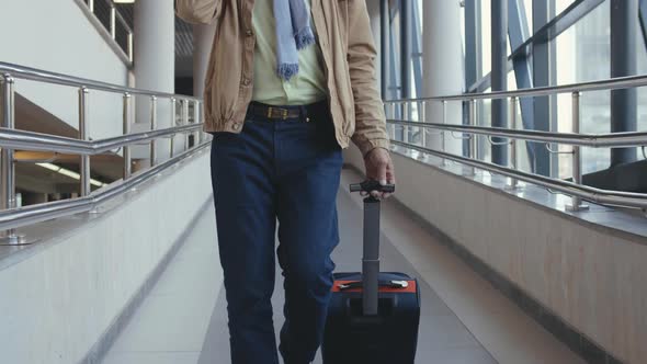 Elegant Mature Businessman Walking in a Public Transportation Station