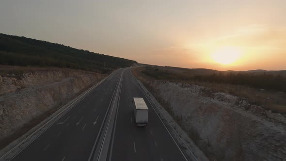 White Transport Truck Driving on the Sunset Road