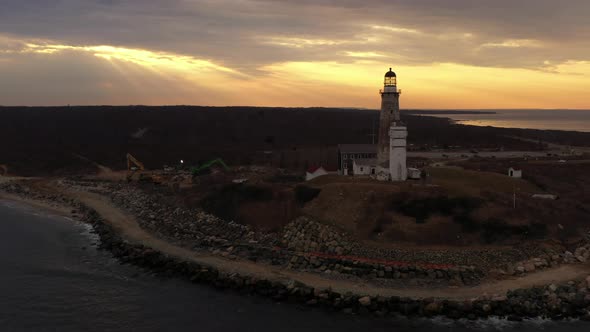 An aerial view of the Montauk lighthouse during a golden sunset. The drone camera dolly in towards a